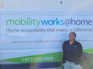 A person stands in front of a van labeled mobilityworks@home, offering home accessibility solutions and services, including stairlift installations.